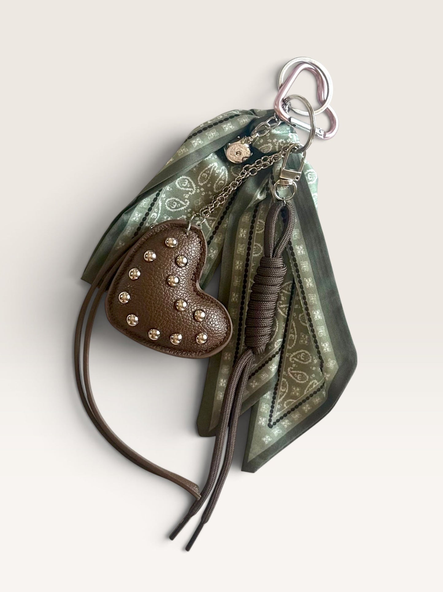 Porte-clé cœur marron clouté avec foulard vert à motifs de CosmicsJewels sur fond blanc