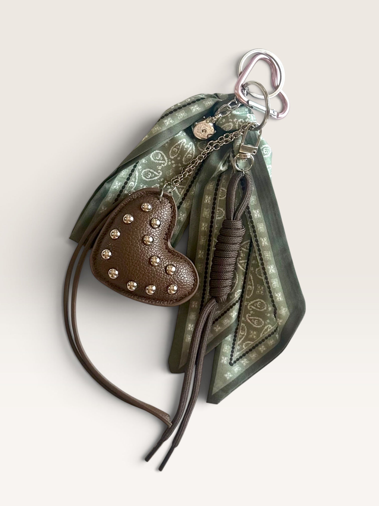 Porte-clé cœur marron clouté avec foulard vert à motifs de CosmicsJewels sur fond blanc
